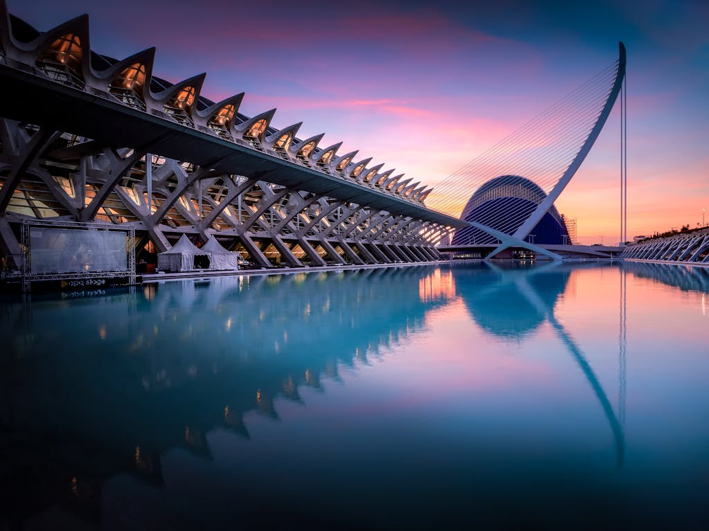 Stunning view of Valencia's City of Arts and Sciences reflecting in water at sunset.